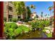 Landscaped pond with lush greenery, trees, and building with red tile roof in the background at 10330 W Thunderbird Blvd # C207, Sun City, AZ 85351