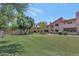 Well-maintained condo exterior with lush green lawn and mature trees, providing a serene and inviting atmosphere at 1075 E Chandler Blvd # 210, Chandler, AZ 85225