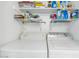 Laundry area with a side-by-side washer and dryer, and well-organized shelving for laundry products at 1075 E Chandler Blvd # 210, Chandler, AZ 85225