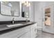 Bathroom with double sinks, grey counters, white cabinets, and access to outside at 15131 W Melissa Ln, Surprise, AZ 85374