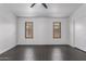 Bedroom with tile floors, a ceiling fan and two windows with a glimpse of the outside at 15131 W Melissa Ln, Surprise, AZ 85374