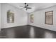 Bright bedroom with wood-look tile flooring, multiple windows and ceiling fan at 15131 W Melissa Ln, Surprise, AZ 85374