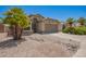 Charming home with desert landscaping, beautiful palm trees, and a spacious driveway leading to a two-car garage at 15131 W Melissa Ln, Surprise, AZ 85374