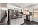 Bright kitchen with stainless appliances, a center island, and dark wood floors, offering a modern design at 15131 W Melissa Ln, Surprise, AZ 85374