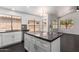 Spacious kitchen island with dark counters and white cabinetry, complemented by modern finishes and ample natural light at 15131 W Melissa Ln, Surprise, AZ 85374