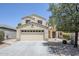 Inviting two-story home featuring a neutral color palette, desert landscaping, and attached two-car garage at 15205 N Honcho Ct, El Mirage, AZ 85335