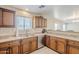 This kitchen has a stainless steel dishwasher, double sink and wood cabinets with granite countertops at 15205 N Honcho Ct, El Mirage, AZ 85335