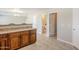 An open floor plan with an island, wood cabinets and a half wall looks into the dining room at 15205 N Honcho Ct, El Mirage, AZ 85335