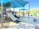 Community playground with a slide, picnic tables, and shaded areas for children to enjoy at 15205 N Honcho Ct, El Mirage, AZ 85335