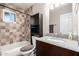 Bathroom with brown patterned tile surround the shower/bath, toilet, sink and granite countertop at 1531 W Campo Bello Dr, Phoenix, AZ 85023