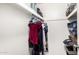White closet with upper shelf, hanging rod with hangers and some clothing at 1531 W Campo Bello Dr, Phoenix, AZ 85023
