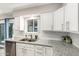 Close-up of a kitchen featuring white cabinets, granite countertops, stainless steel sink, and a view to the backyard at 1531 W Campo Bello Dr, Phoenix, AZ 85023