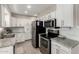 Well-equipped kitchen with stainless steel appliances, white cabinetry, granite countertops, and tile backsplash at 1531 W Campo Bello Dr, Phoenix, AZ 85023