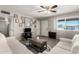 Living room featuring wood laminate flooring, a ceiling fan, neutral paint, and ample natural light at 1531 W Campo Bello Dr, Phoenix, AZ 85023