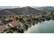 Aerial shot of a home with a pool and lush landscaping bordering a scenic lake and mountain backdrop at 16239 S 18Th Pl, Phoenix, AZ 85048
