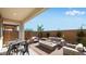 Covered patio with a cozy seating arrangement, fire pit, table and a beautiful view of landscaping at 16762 W Alameda Rd, Surprise, AZ 85387