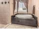Bright bathroom with a large soaking tub and window with decorative curtains at 1758 E Carver Rd, Tempe, AZ 85284