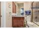 Well-lit bathroom with wood cabinetry, granite countertops, and a tiled shower at 1758 E Carver Rd, Tempe, AZ 85284