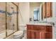 Bathroom featuring shower-tub, glass door, granite-topped vanity and wood cabinets at 1758 E Carver Rd, Tempe, AZ 85284