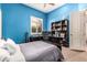 Well-lit bedroom showcasing blue walls, white doors, a desk, and neutral carpet at 1758 E Carver Rd, Tempe, AZ 85284