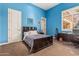 Bedroom with a contrasting design featuring bright blue walls, a dark bed frame, and a desk at 1758 E Carver Rd, Tempe, AZ 85284
