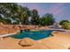 Luxurious pool area with rock formations and mature trees creating a private and serene outdoor oasis at 1758 E Carver Rd, Tempe, AZ 85284