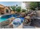 Backyard pool and jacuzzi with a rock waterfall feature at 1758 E Carver Rd, Tempe, AZ 85284