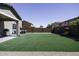 A spacious backyard showing the artificial grass and exterior layout of the property at 1972 N Hubbard Ln, Casa Grande, AZ 85122