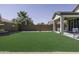 Large backyard with green lawn, covered patio, and block wall offering privacy at 1972 N Hubbard Ln, Casa Grande, AZ 85122