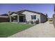 This backyard features a covered patio, green lawn, and gravel area perfect for outdoor entertaining at 1972 N Hubbard Ln, Casa Grande, AZ 85122