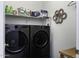 Modern laundry room with front loading washer and dryer, complete with ample shelving at 1972 N Hubbard Ln, Casa Grande, AZ 85122
