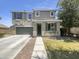 Charming two-story home featuring a well-maintained lawn, a two car garage, and a welcoming covered porch at 21262 E Cherrywood Dr, Queen Creek, AZ 85142