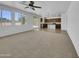 Spacious living room featuring carpet, large windows, and an open floor plan leading to kitchen at 21262 E Cherrywood Dr, Queen Creek, AZ 85142