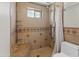 Tiled shower with seat and adjustable shower head, adjacent to toilet at 2745 E Dahlia Dr, Phoenix, AZ 85032