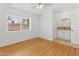 Bright bedroom with wood-look floors, ceiling fan and window offering views, adjacent to a bathroom at 2745 E Dahlia Dr, Phoenix, AZ 85032