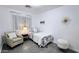 Inviting bedroom with floral bedding, a comfortable chair, and a faux fur stool, creating a relaxing and welcoming retreat at 3128 E Desert Cove Ave, Phoenix, AZ 85028