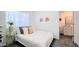 Cozy bedroom with white bedding and decorative pillows, adjacent to a modern bathroom with sleek finishes at 3128 E Desert Cove Ave, Phoenix, AZ 85028