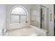 Bright bathroom features a soaking tub with window and a glass enclosed shower at 3550 E Edna Ave, Phoenix, AZ 85032