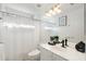 Bright bathroom features a shower, toilet, vanity with sink, large mirror, and decorative lighting at 3550 E Edna Ave, Phoenix, AZ 85032