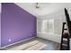 Bright bedroom featuring a purple accent wall, wood floors, and a ceiling fan at 3550 E Edna Ave, Phoenix, AZ 85032