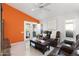 Open living room with an accent wall, plantation shutters, comfortable leather seating, and a ceiling fan at 3550 E Edna Ave, Phoenix, AZ 85032