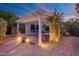 Covered patio at dusk is illuminated by landscape lighting and features a seating area and fire pit at 3550 E Edna Ave, Phoenix, AZ 85032