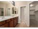 Bathroom featuring double sinks, large mirror, and neutral tile flooring at 42424 N Gavilan Peak Pkwy # 57104, Anthem, AZ 85086