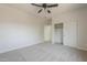 Light-filled bedroom with cozy carpet, ceiling fan, and doors to bedroom closets at 44538 W Canyon Creek Dr, Maricopa, AZ 85139