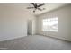 Well-lit bedroom featuring neutral carpet, large window, and a ceiling fan at 44538 W Canyon Creek Dr, Maricopa, AZ 85139