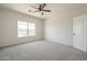 Inviting bedroom showcasing a large window, carpeted floors, and a contemporary ceiling fan at 44538 W Canyon Creek Dr, Maricopa, AZ 85139