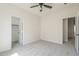 Bright bedroom featuring plush carpet, ceiling fan, and two doors for closet access at 44538 W Canyon Creek Dr, Maricopa, AZ 85139