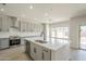 Modern kitchen with a large island, stainless steel appliances, gray cabinets, and quartz countertops at 44538 W Canyon Creek Dr, Maricopa, AZ 85139