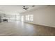 Spacious living room featuring light floors, a ceiling fan, and sliding doors to the backyard at 44538 W Canyon Creek Dr, Maricopa, AZ 85139
