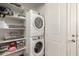 Organized laundry room featuring stacked washer and dryer with ample storage shelves at 45424 W Norris Rd, Maricopa, AZ 85139